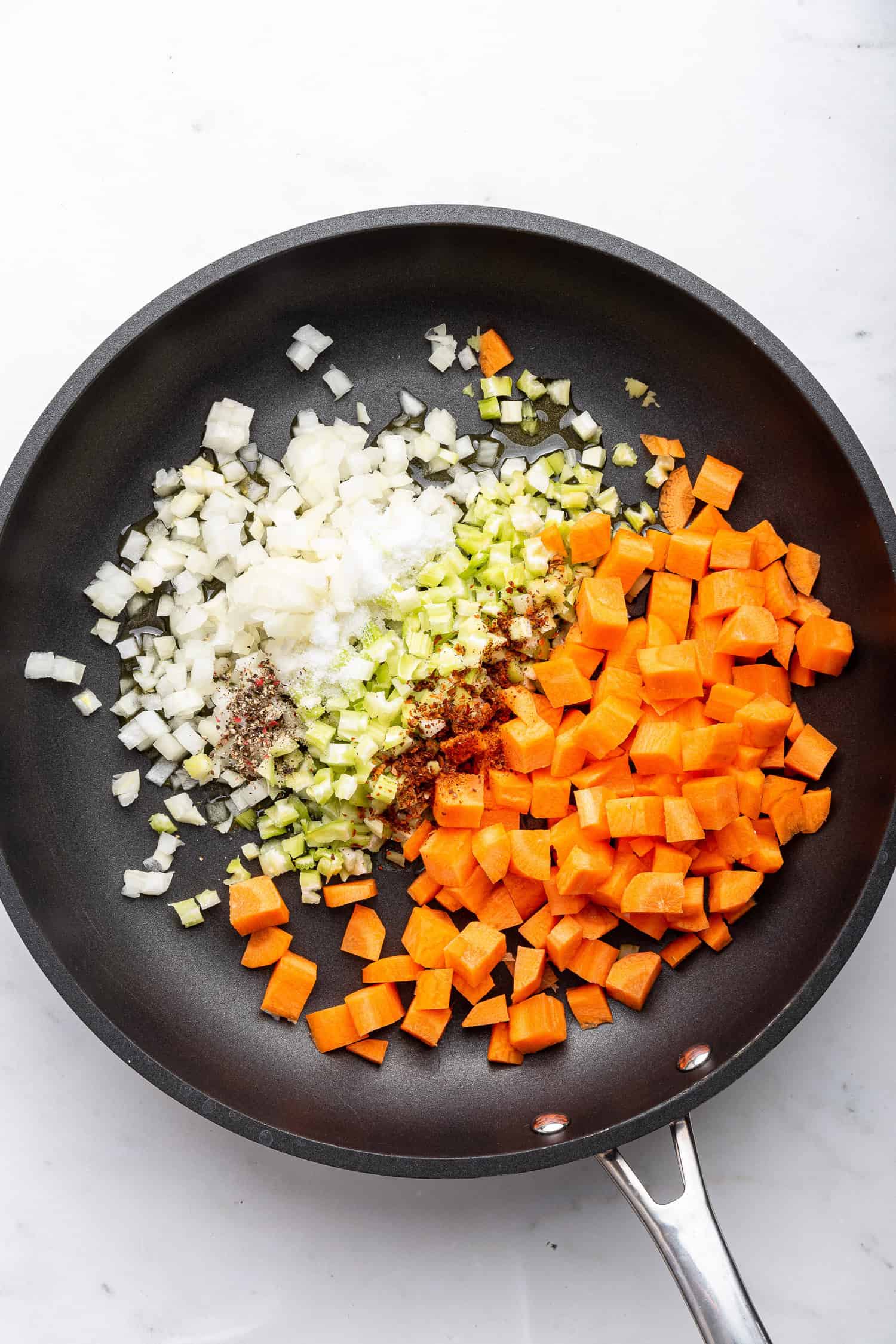 Chopped onions, carrots, and celery in a pan. 