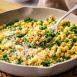 Pasta and peas with large serving spoon.