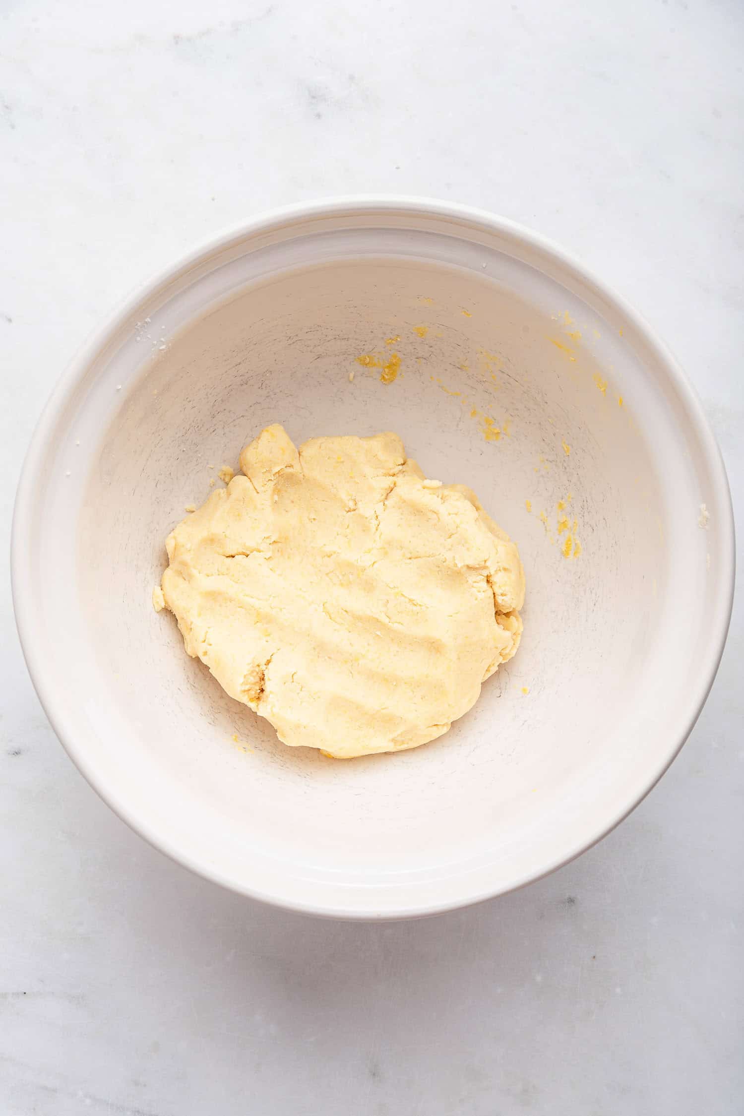 Pie dough squeezed together in a white bowl. 