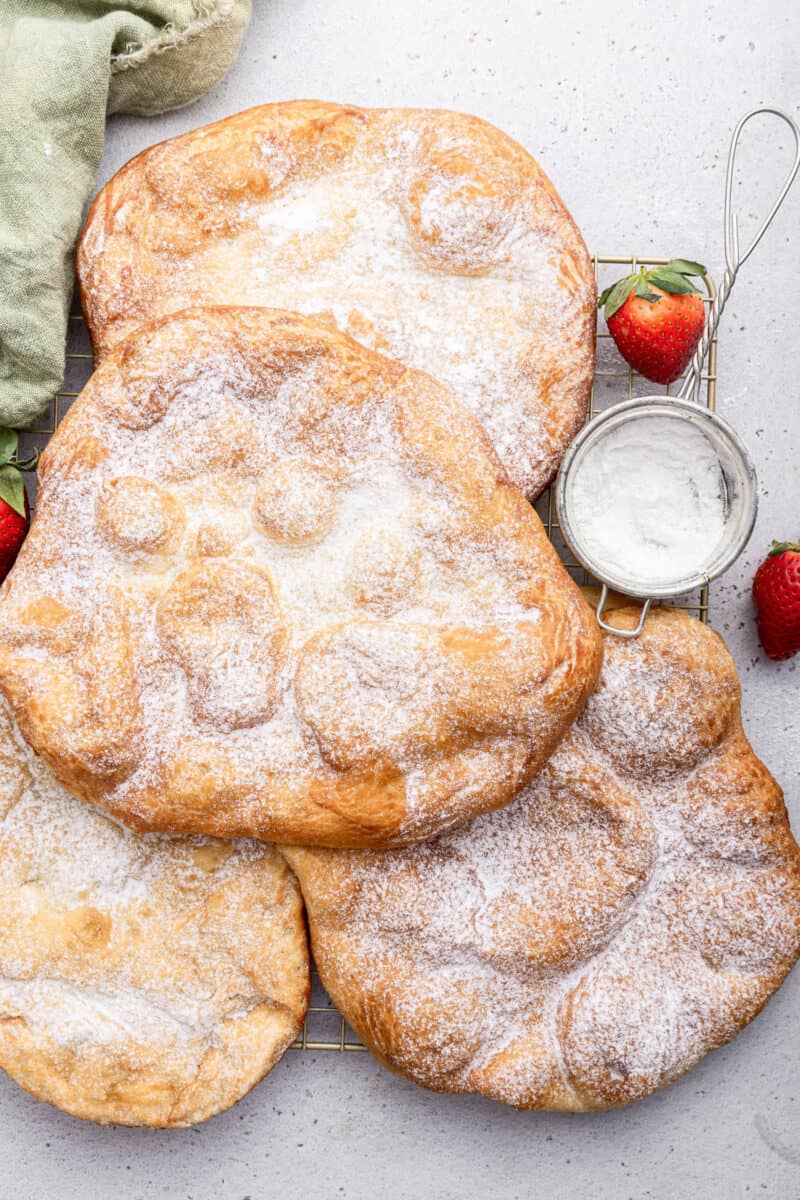 Circles of fried dough also called pizza fritta topped with powdered sugar.