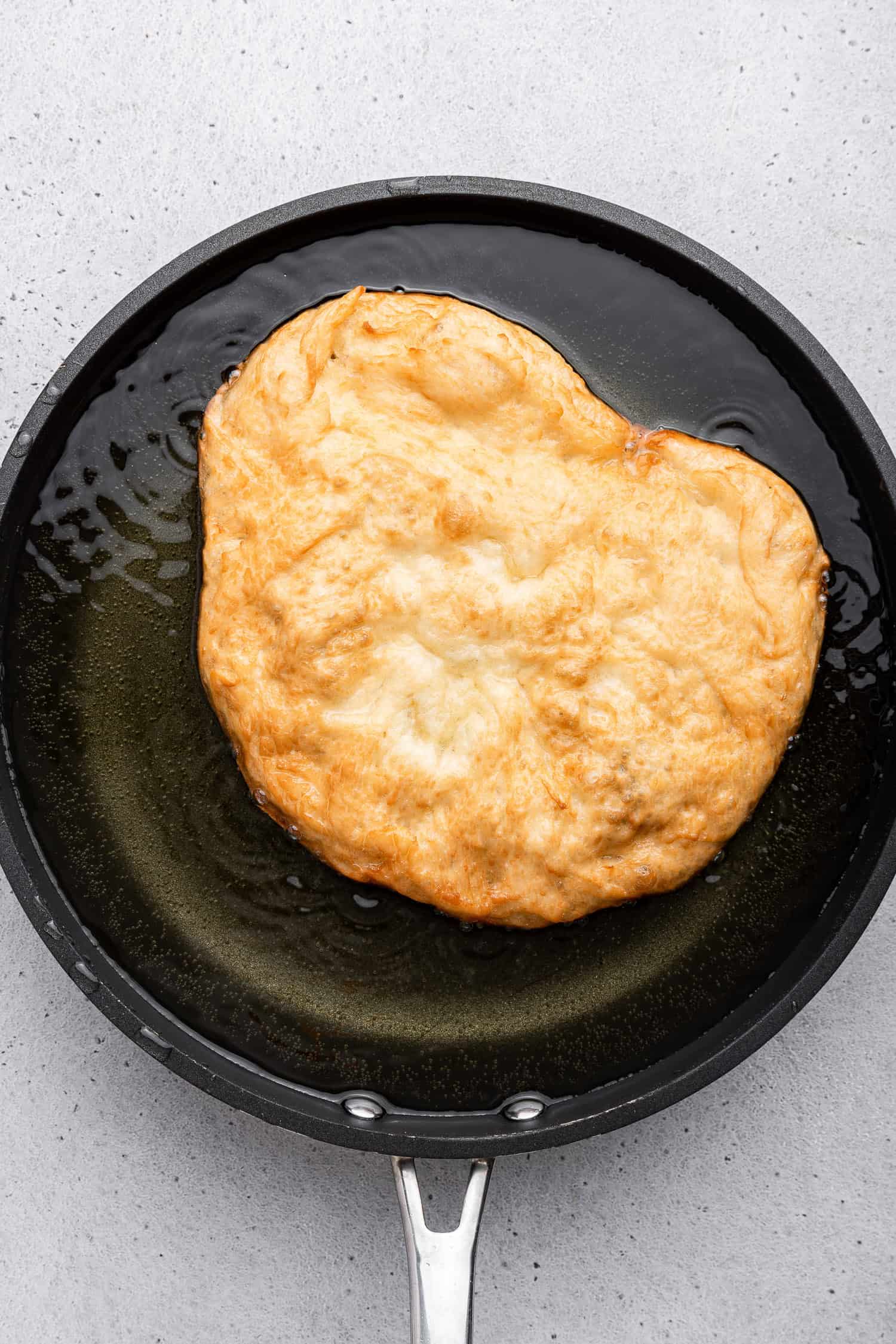 Pizza fritta frying in oil in pan. 