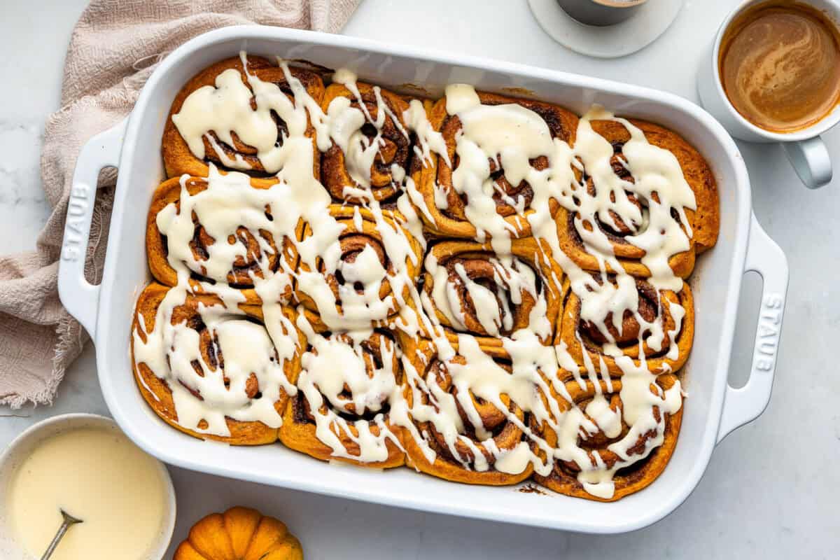 Pumpkin cinnamon rolls in white pan.