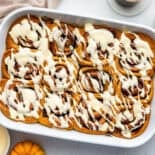 Pumpkin cinnamon rolls in white pan.