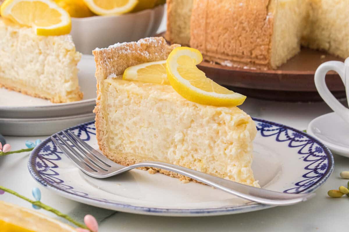 Slice of Italian rice pie on blue and white plate with slice of lemon garnish. 