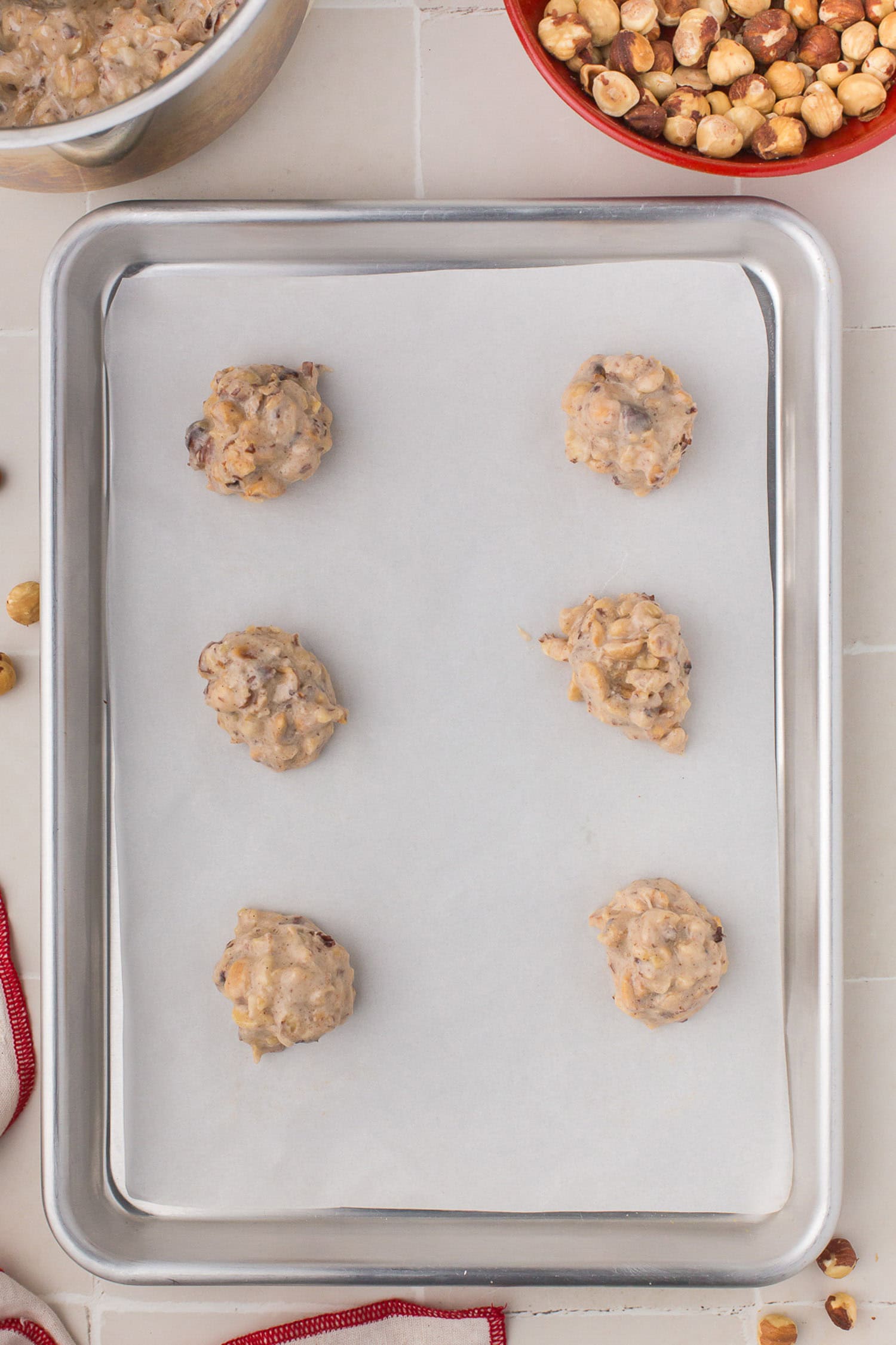 Unbaked cookies on parchment lined sheet. 