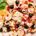 Top view of Italian seafood salad with olives, red pepper and celery.