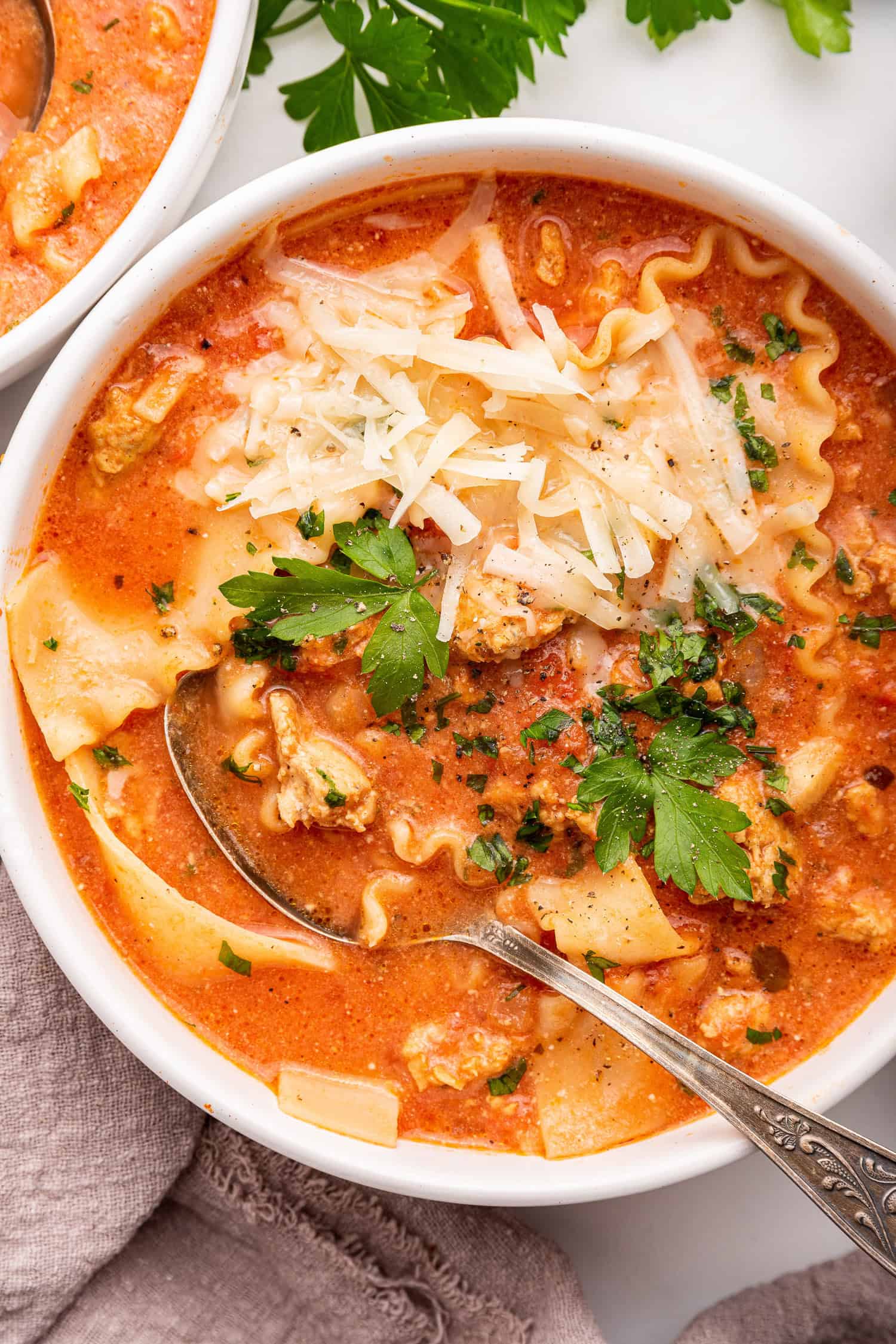 Bowl of lasagna soup with spoon in white bowl.