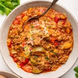 Stuffed pepper soup in white bowl in spoon.