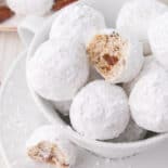 Bowl of snowball cookies with bite taken out.