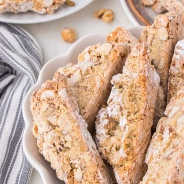 Italian nut biscotti on white scalloped dish.