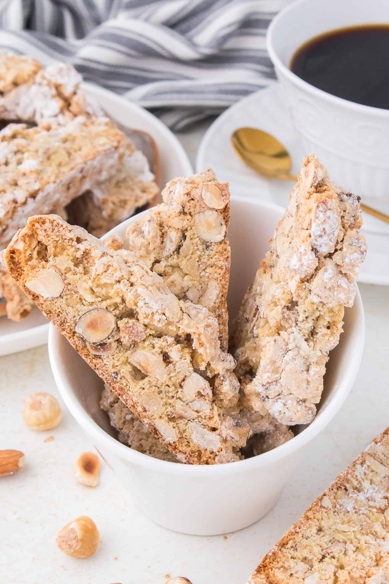 Biscotti in bowl with coffee on side. 