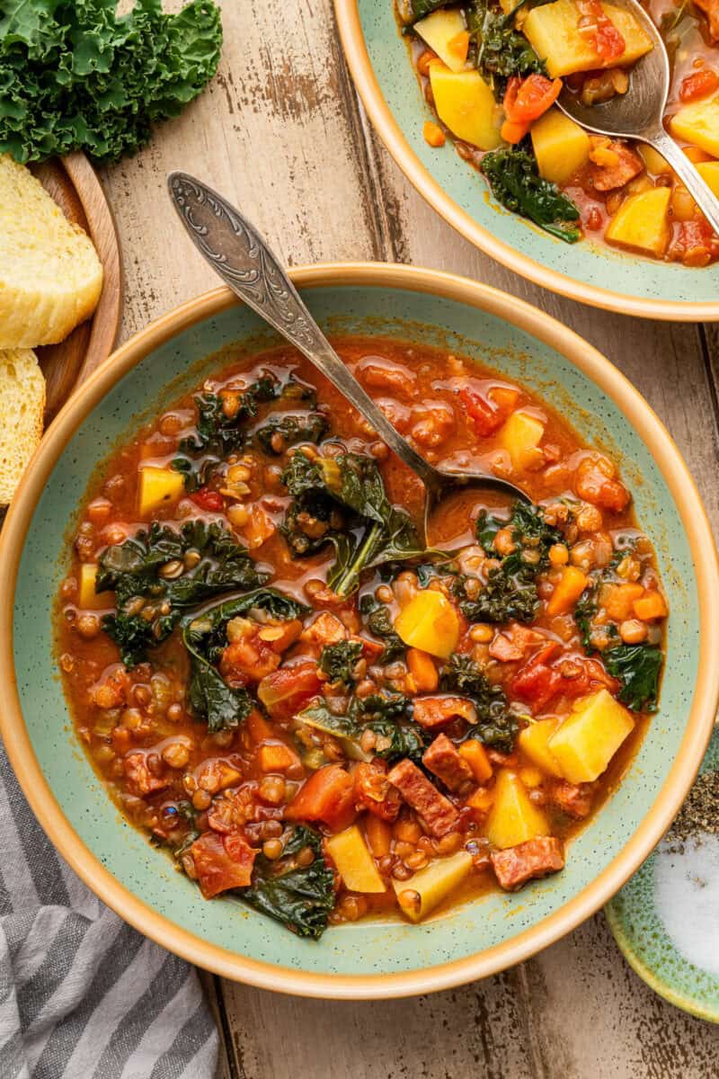 Lentil and Sausage soup in bowl with spoon.