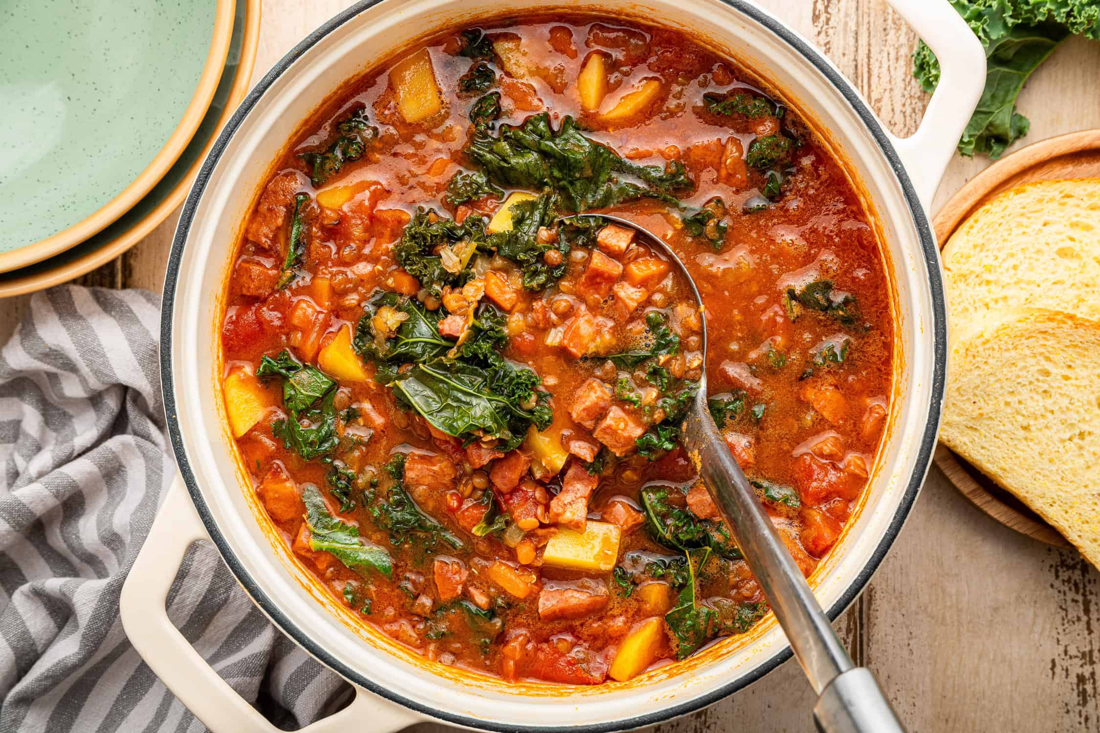 Italian lentil and sausage soup in bowl with spoon. 