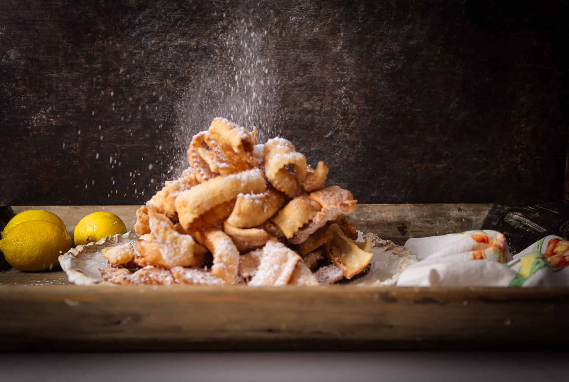 Dish of fried crostoli sprinkled with powdered sugar.