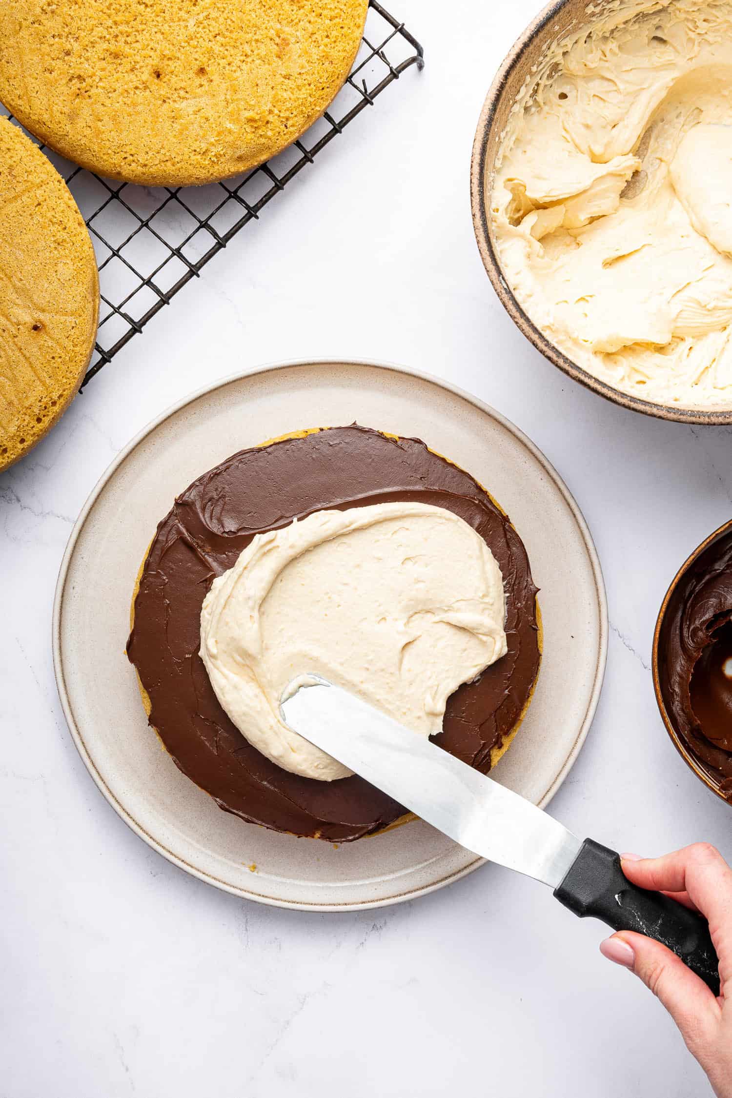 Adding chocolate and frosting to cake layers. 