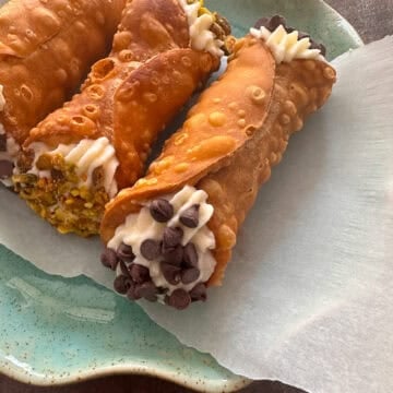 Filled Italian cannoli on blue plate.