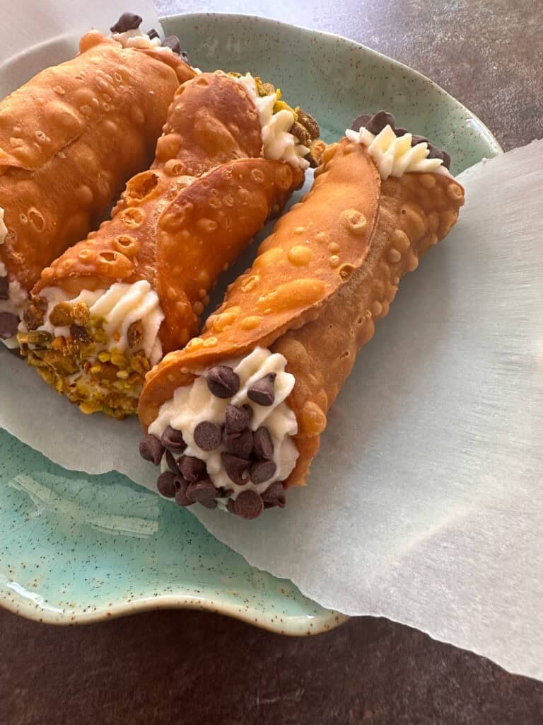 Filled Italian cannoli on blue plate.