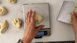 A person is using a scale to weigh dough.