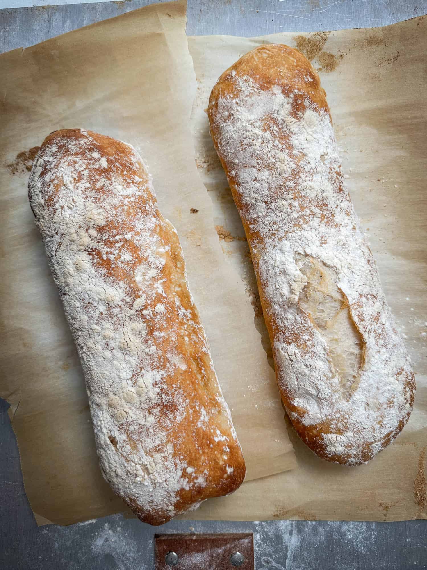Two loaves of bread sitting on a baking sheet.