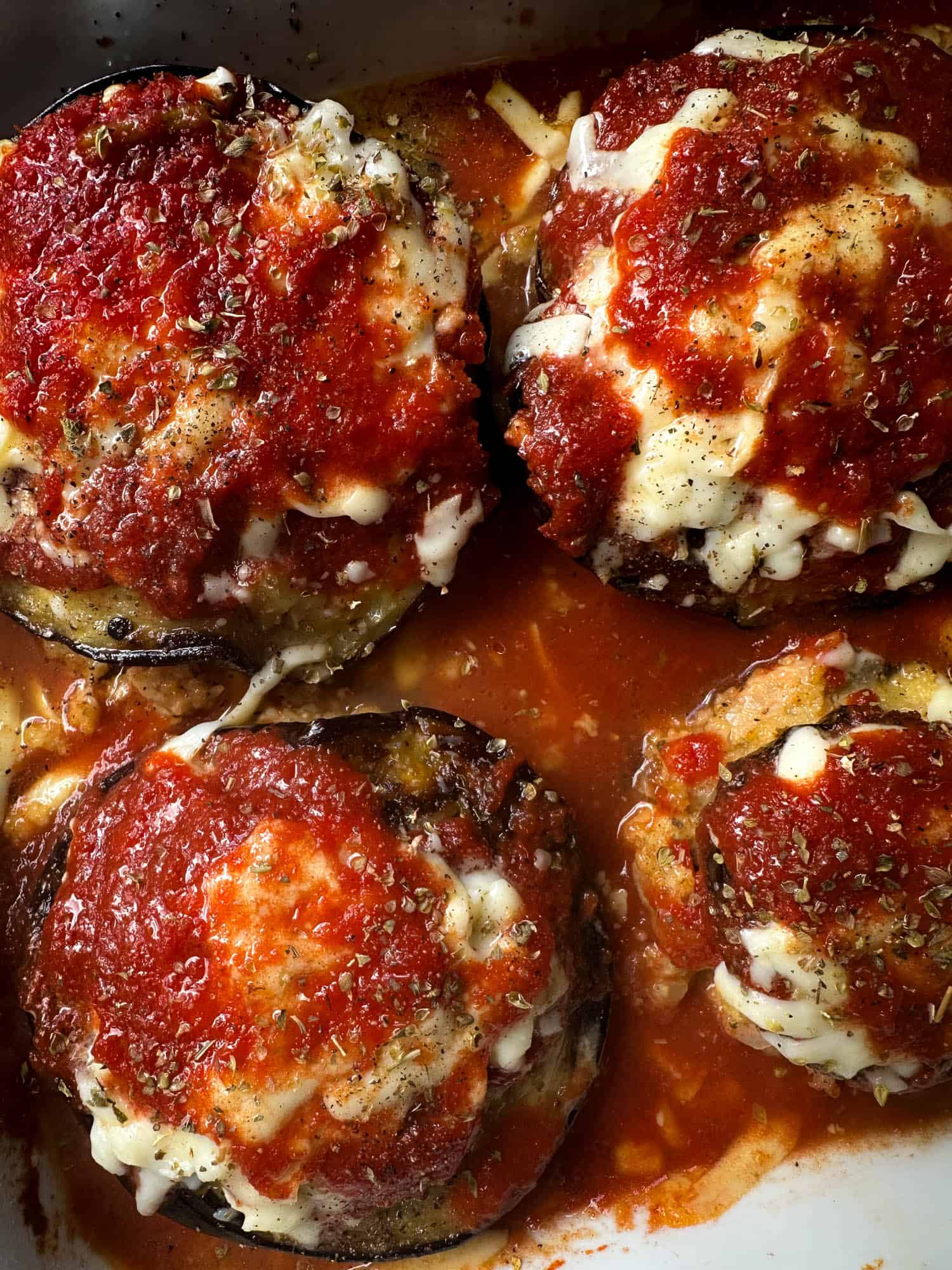 Baked stuffed eggplant with melted cheese and tomato sauce.