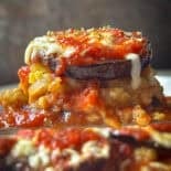 Creamy stuffed eggplant topped with melted cheese and tomato sauce. Delicious vegetarian baked dish with herbs and seasonings.