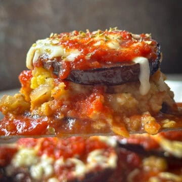 Creamy stuffed eggplant topped with melted cheese and tomato sauce. Delicious vegetarian baked dish with herbs and seasonings.
