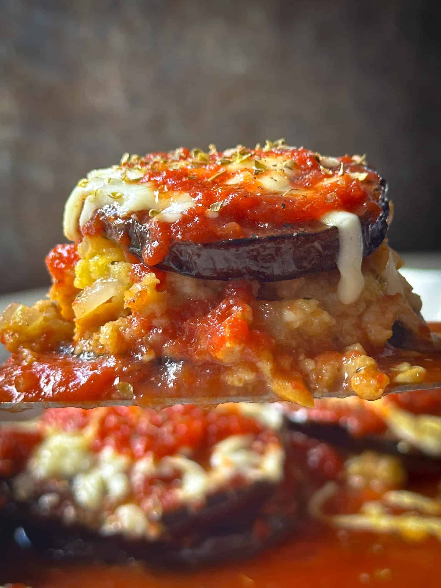 Creamy stuffed eggplant topped with melted cheese and tomato sauce. Delicious vegetarian baked dish with herbs and seasonings.