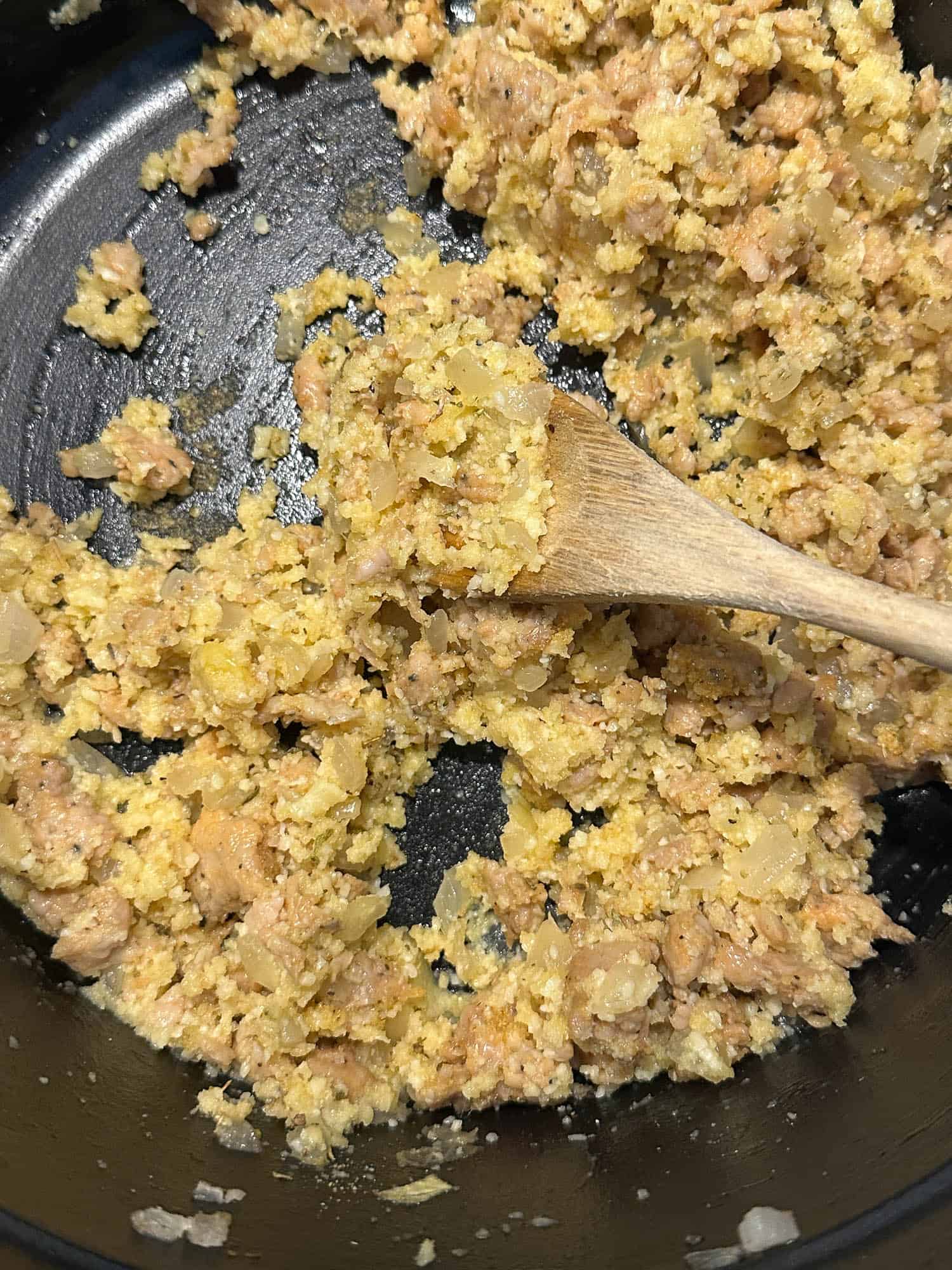 Sausage stuffing in a black skillet, ready to layer on the eggplant slices.