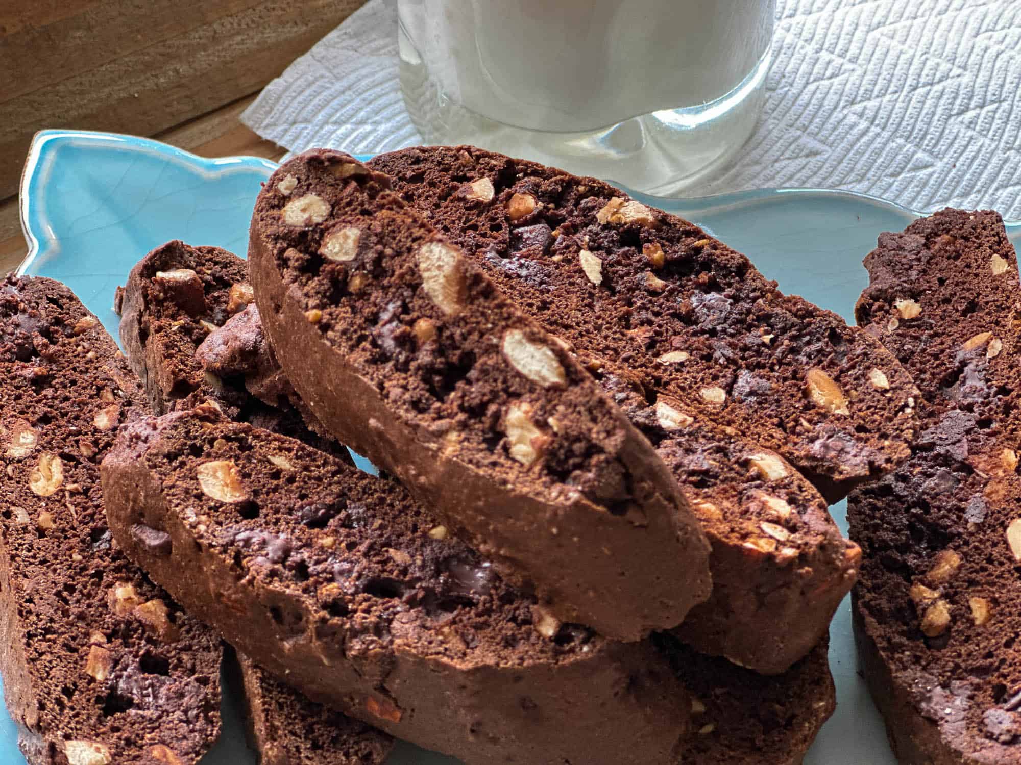 Chewy chocolate biscotti with nuts on a blue plate, perfect for coffee or tea.