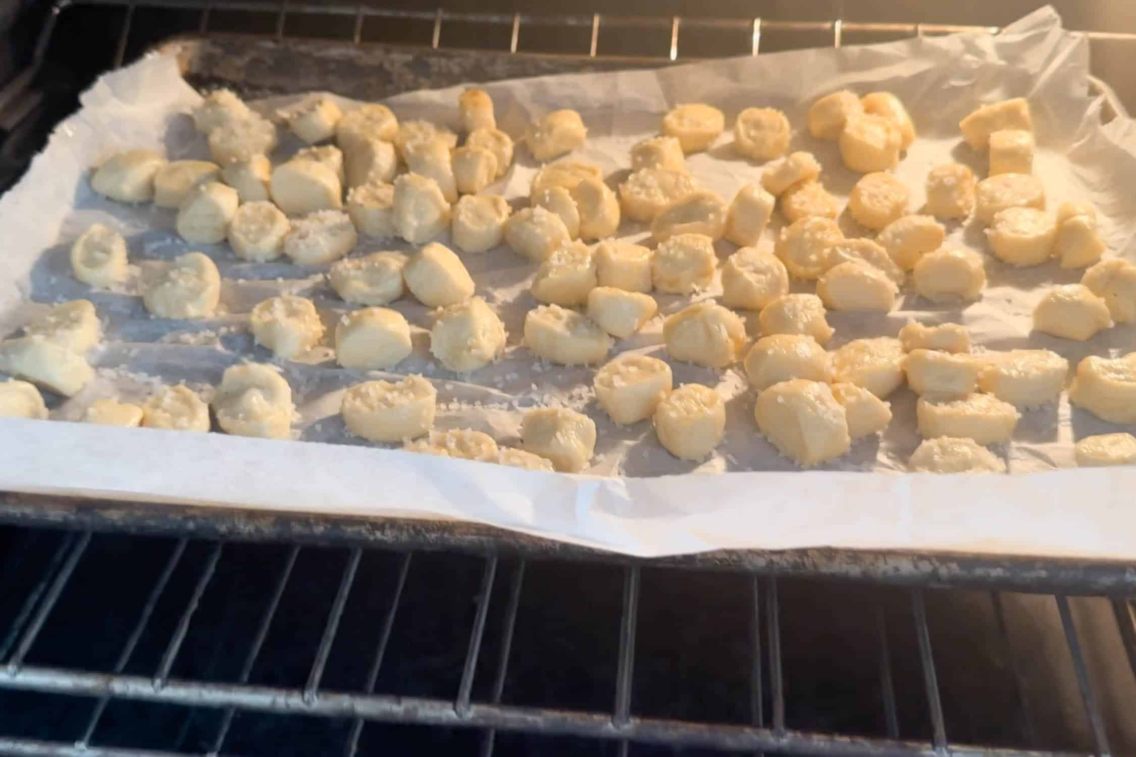 Delicious sourdough discard pretzel bites baking on a tray in the oven ready to bake.