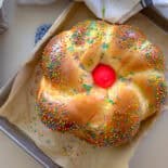 Loaf of italian easter bread with pink egg and sprinkles.