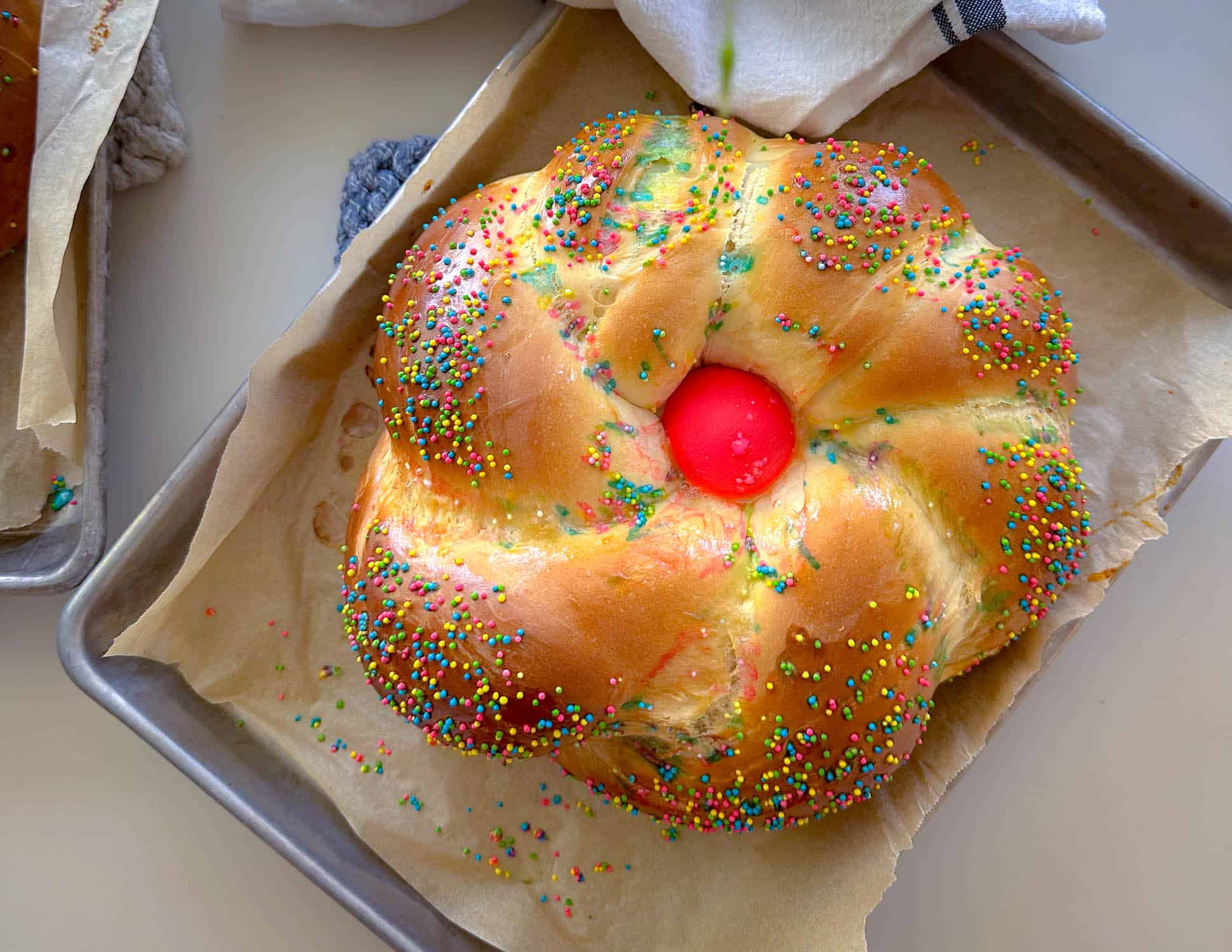 Loaf of italian easter bread with pink egg and sprinkles.