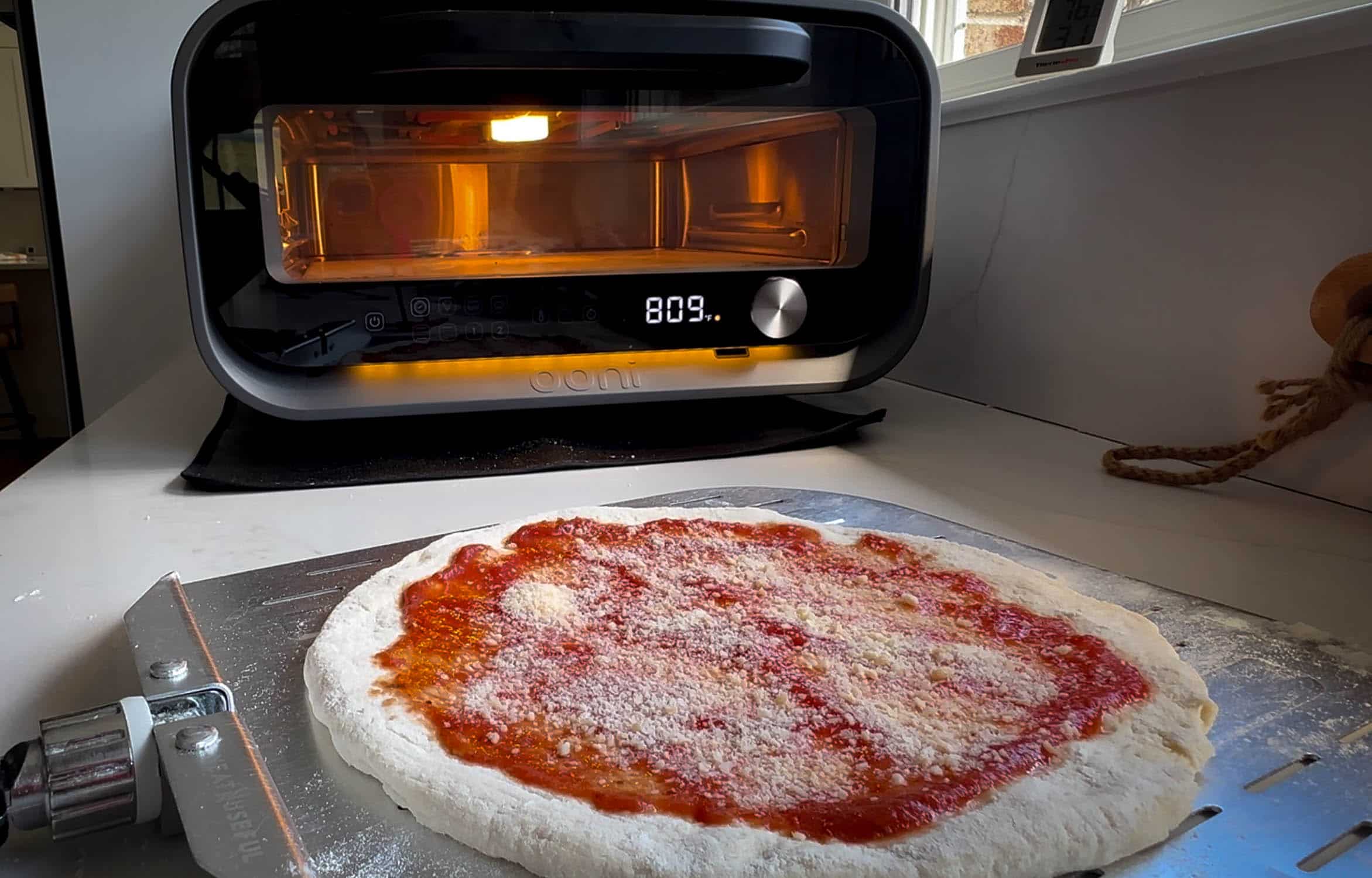 Front of Ooni Volt 2 with pizza in front ready to load. 