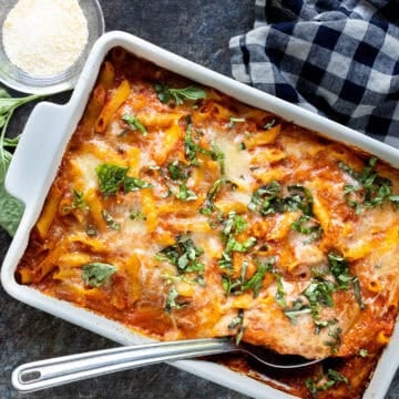 Overhead view of baked ziti in white baking dish.