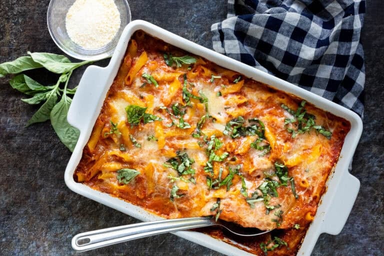 Overhead view of baked ziti in white baking dish.